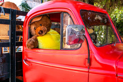 Teddy bear at driver's seat of vintage truck