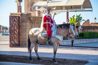 Full length of honor guard sitting on horse against entrance