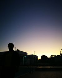 Rear view of silhouette man standing against sky during sunset