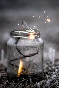 Close-up of lit candles on field at night