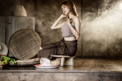 Full length of a woman sitting on table