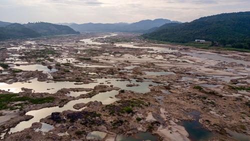 High angle view of river and mountains against sky
