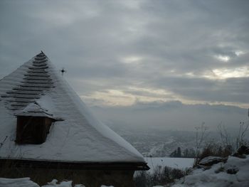 Snow covered house against sky