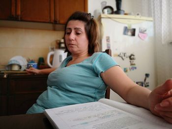 Midsection of woman sitting at home