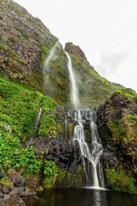 Scenic view of waterfall against sky