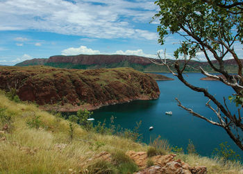 Scenic view of lake by mountains against sky