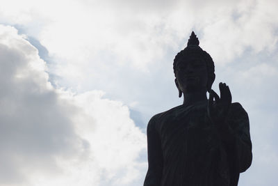 Low angle view of buddha statue against sky