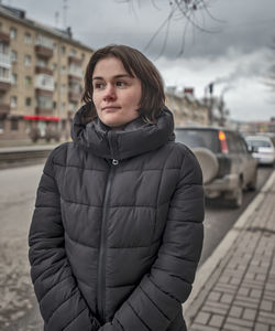 Portrait of woman standing in city during winter