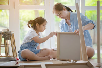 Mother and daughter doing carpentry at home