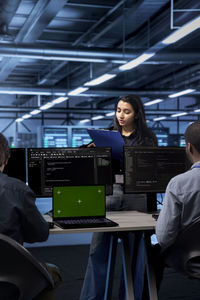 Side view of woman using mobile phone in factory
