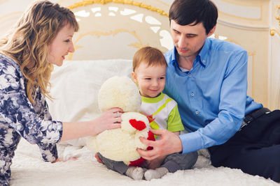 Patent with son sitting on bed with stuffed toy