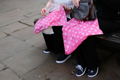 Low section of person standing on pink umbrella