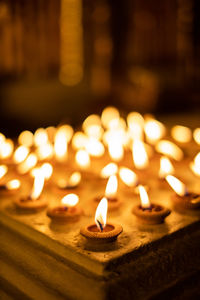 Close-up of burning candles in temple