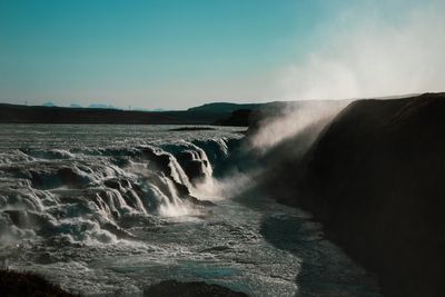 Scenic view of waterfall against sky