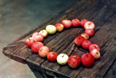 High angle view of apples arranged in heart shape on wooden table