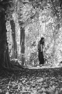 Girl swinging against trees in forest