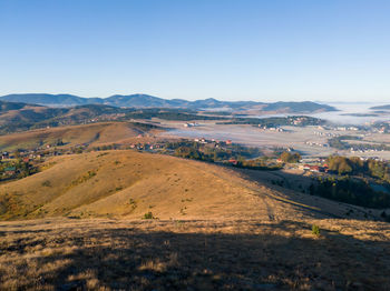 Scenic view of landscape and mountains against clear blue sky