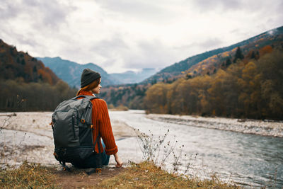 Rear view of man looking at mountains against sky