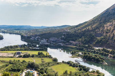 Scenic view of river by mountains against sky