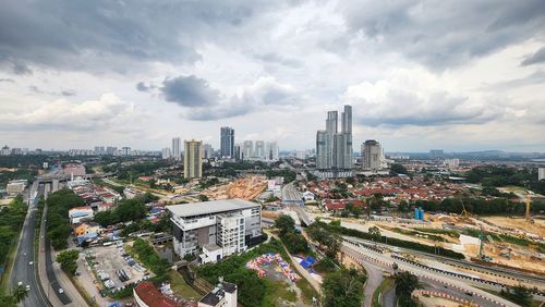 High angle view of cityscape against cloudy sky