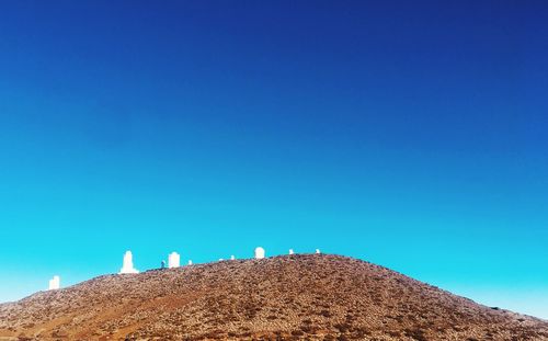 Low angle view of land against clear blue sky