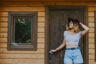 Young girl modern posing in the log cabin