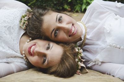 Portrait of smiling bride lying down with friend