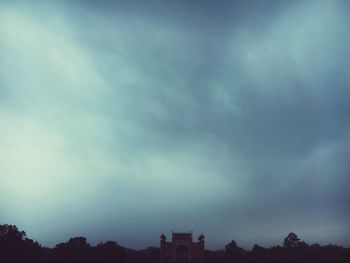 Low angle view of silhouette trees against sky