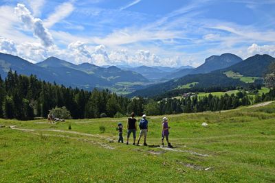 People walking on mountain against sky