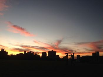 Silhouette city against sky during sunset