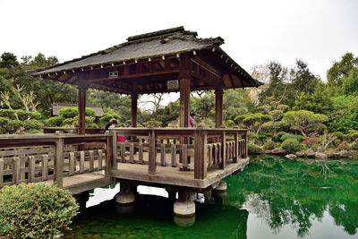 Gazebo by lake against sky