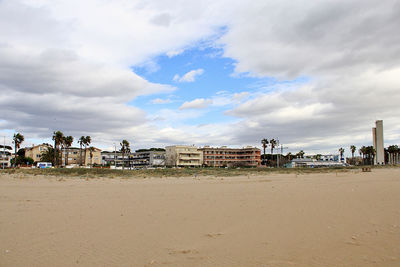 Houses on beach against sky in city