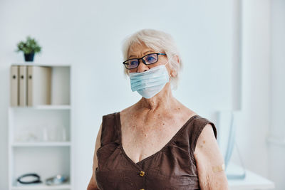 Portrait of woman standing against wall