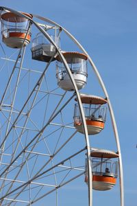 Low angle view of ferris wheel against clear blue sky