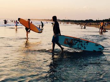 Tourists on beach at sunset