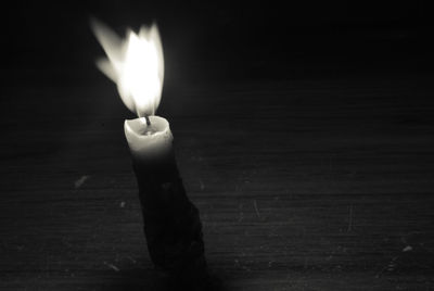 Close-up of lit candle on table