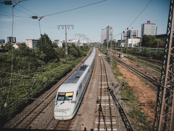 Railroad tracks in city against sky