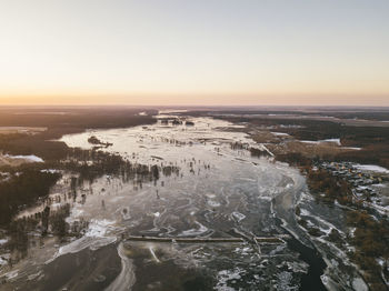 Aerial view of snow covered landscape during sunset