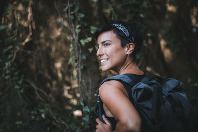 Portrait of young woman looking away in forest