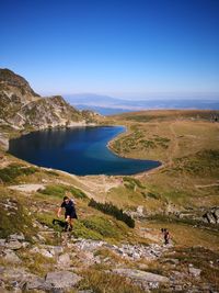 People on mountain against blue sky