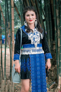 Portrait of woman standing against blue wall