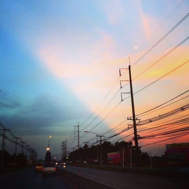 electricity pylon, power line, sunset, sky, transportation, power supply, connection, electricity, cable, road, cloud - sky, power cable, the way forward, orange color, cloud, fuel and power generation, diminishing perspective, built structure, car, street light