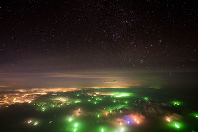 Aerial view of illuminated buildings against sky at night