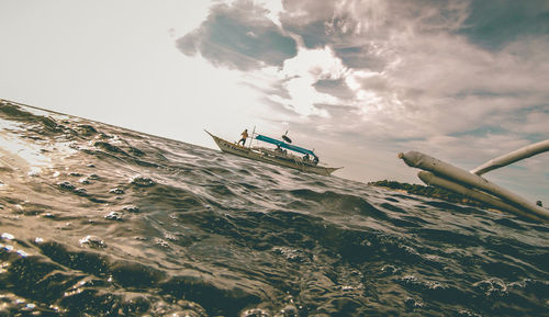 Boat sailing on sea against sky