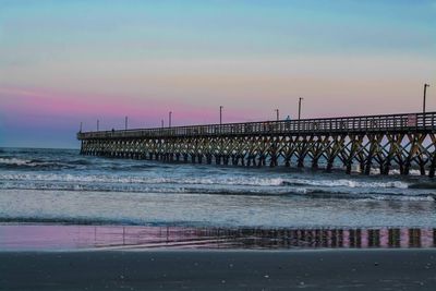 Pier on sea at sunset