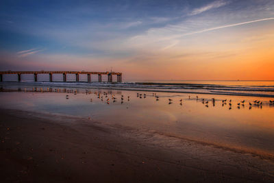 Scenic view of beach against sky during sunset