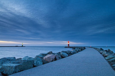 Lighthouse by sea against sky