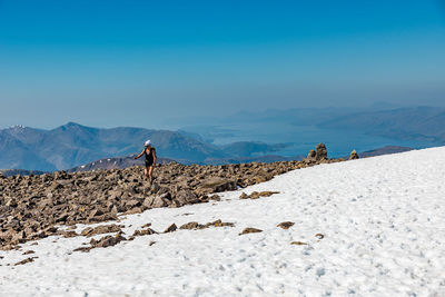 A young female hiker approaching ben nevis summit on hot spring sunny day, fort william, scotland