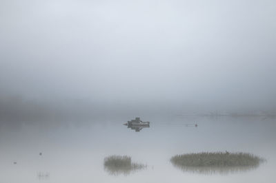 Scenic view of lake in foggy weather