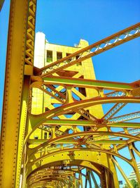 Low angle view of metal structure against blue sky